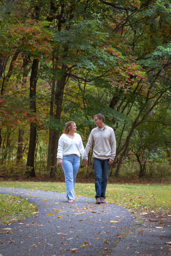Couple walking on leaf-covered path