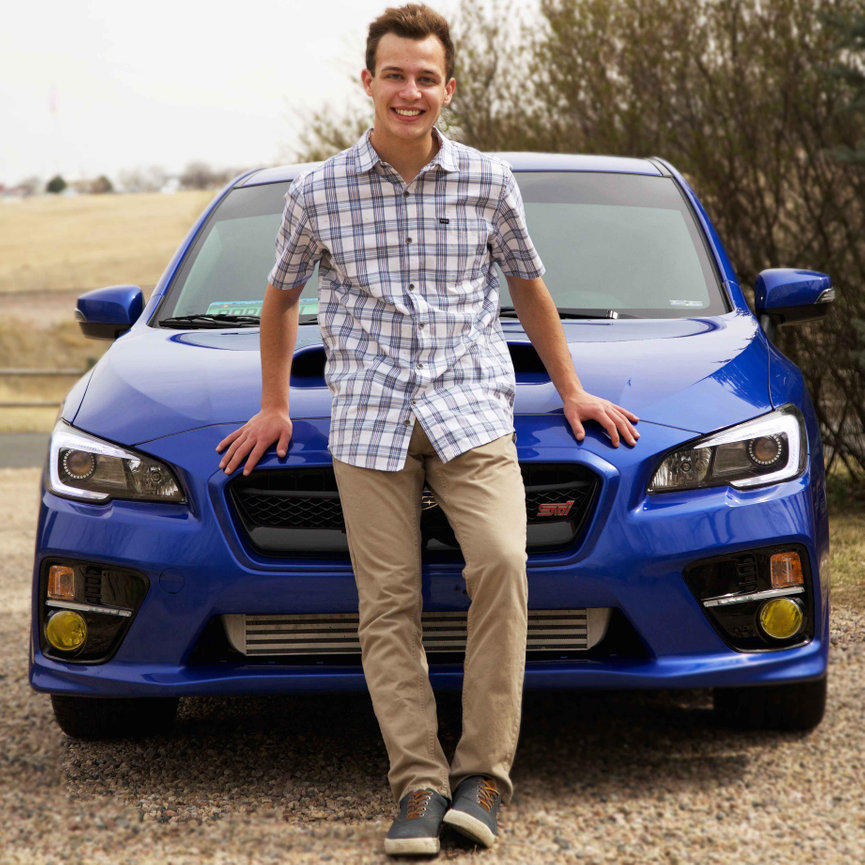 High school senior standing proudly next to his sports car during a personalized portrait session. Captured to celebrate style, individuality, and achievement. Luxury senior portrait experience for Colorado’s discerning families