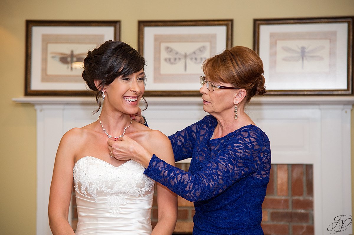 bride getting final touch help from mother