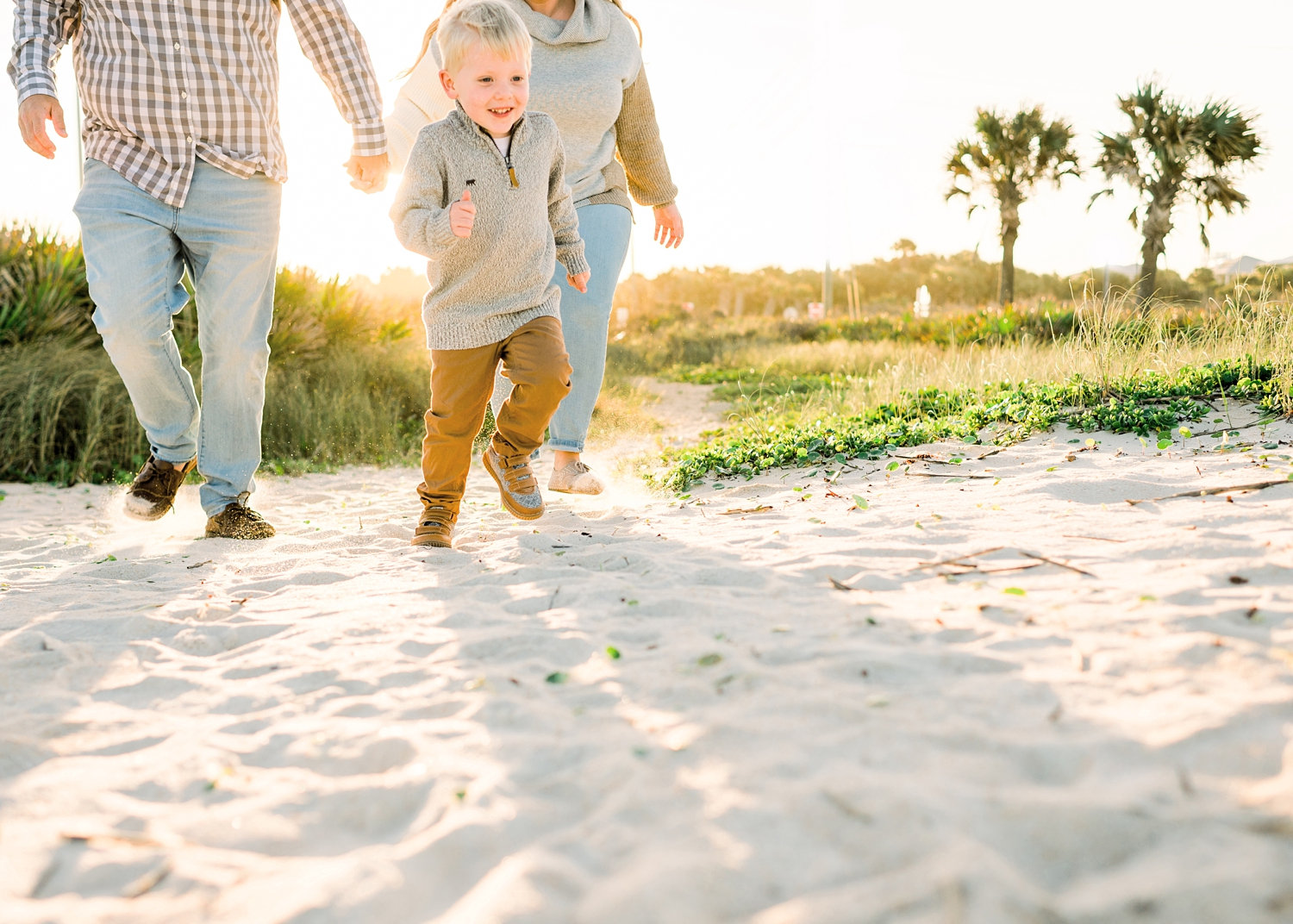 young boy running on beach, mom and dad in the background, Saint Augustine Beach