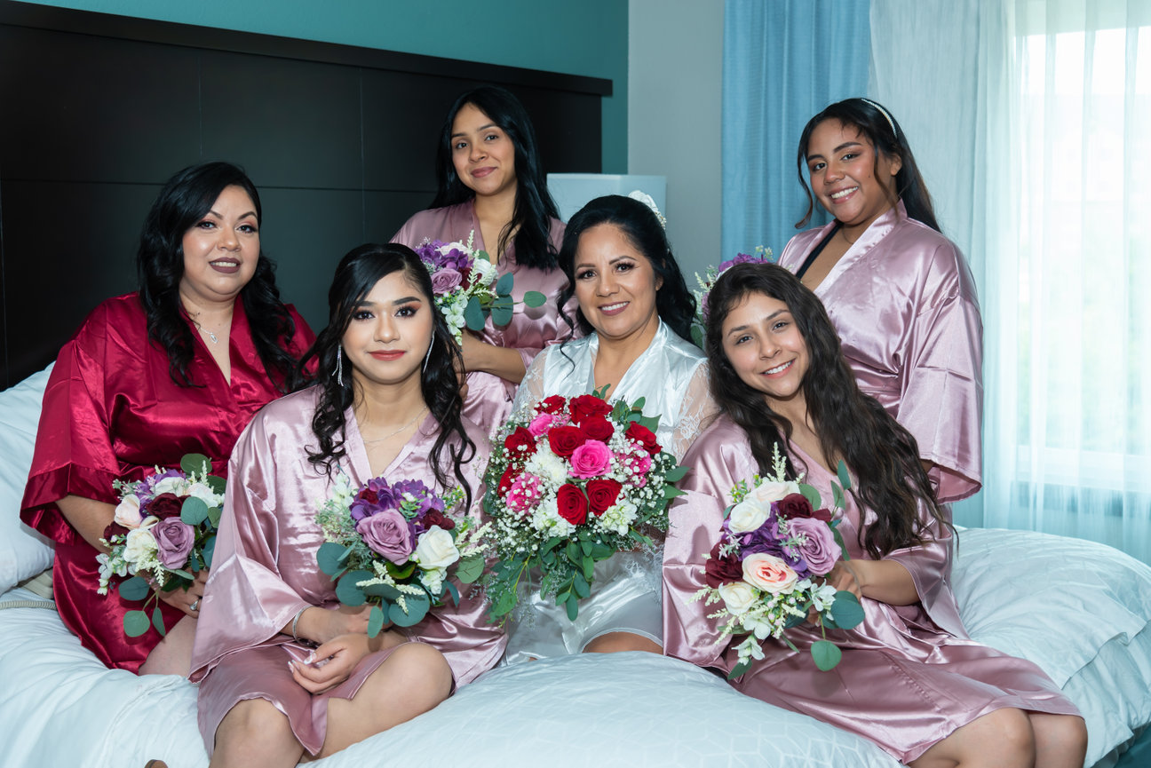 Bridesmaids in matching robes holding flowers