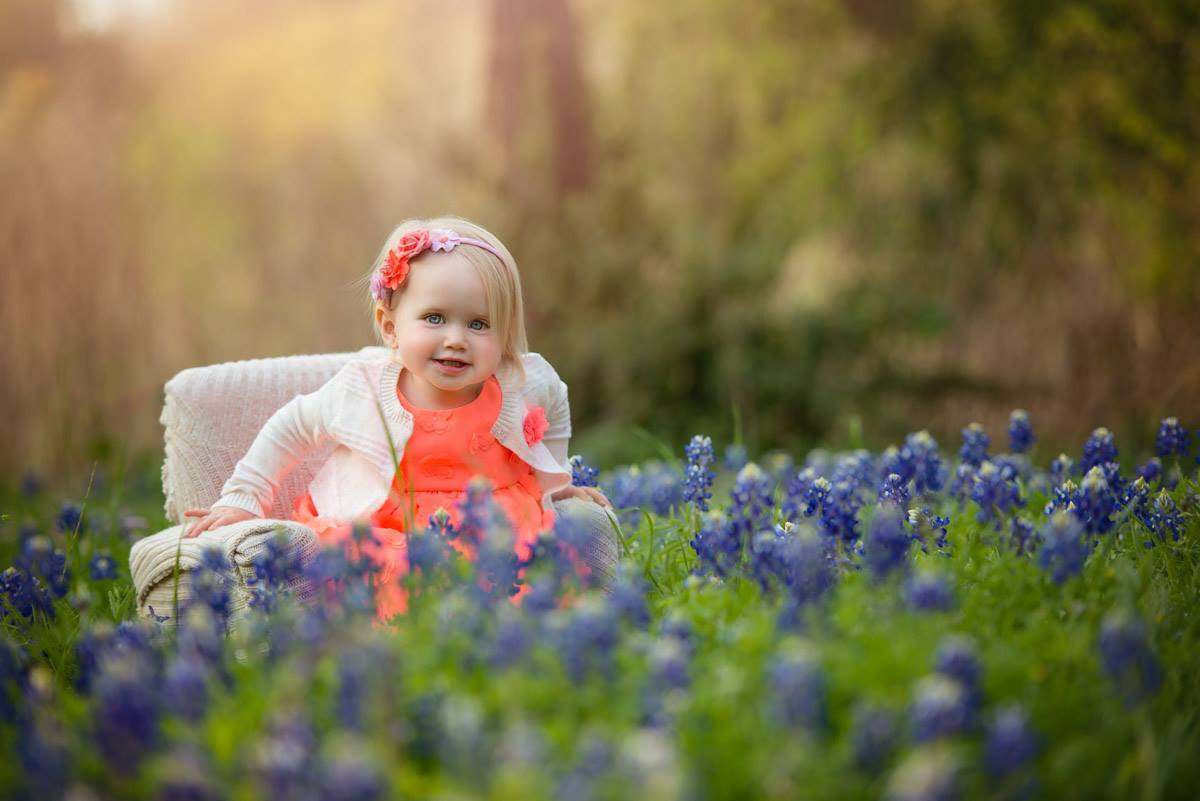 Fine art child portrait in bluebonnet field with vintage chair by Austin portrait photographer Texas Vogue Photography.