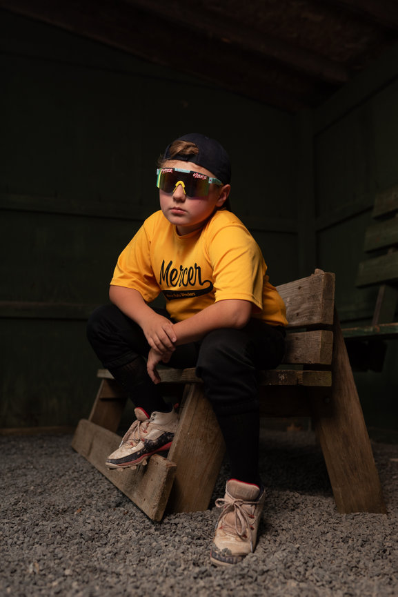baseball player wearing sunglasses sitting out on the bench