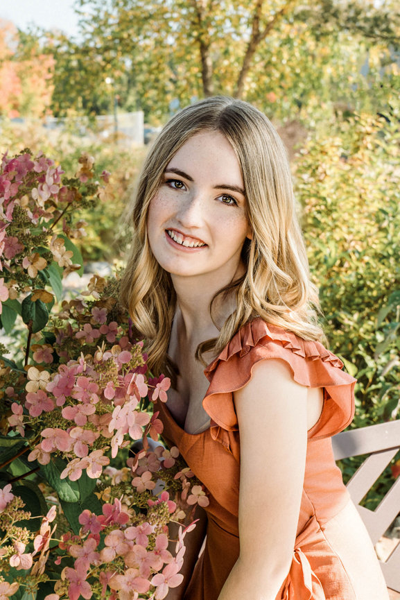 Senior picture of a girl in an orange dress with pink flowers in Minneapolis Minnesota
