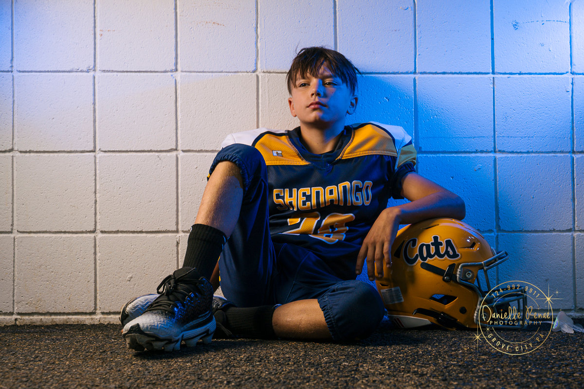 football player leaned against a blue wall