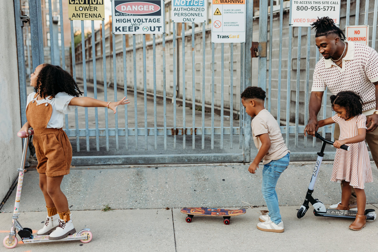 Huntsville Alabama downtown photoshoot Black children ride scooters down city sidewalk