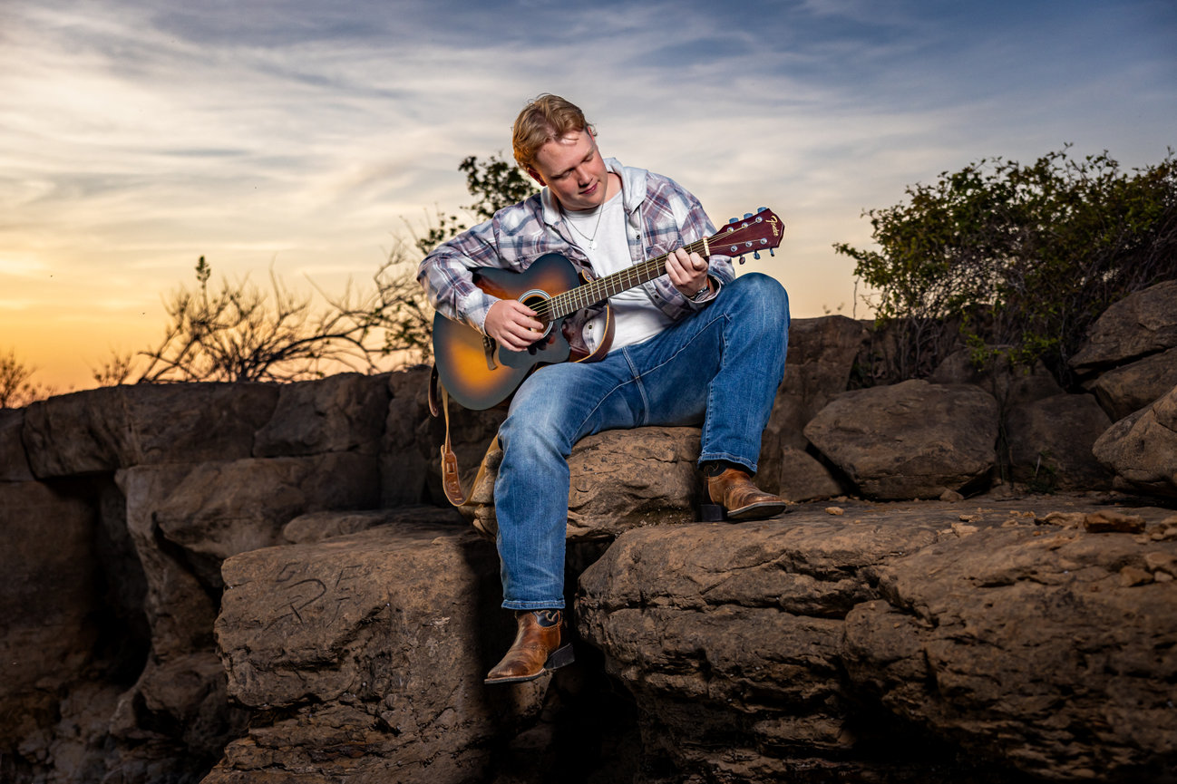 Senior Picture Guy playing guitar at sunset