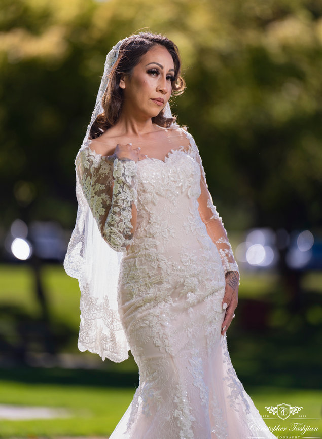 Bride posing in elegant lace wedding dress outdoors