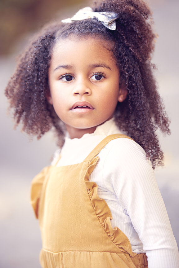Outdoor close-up portrait of a young child in Carmel, Indiana, captured in natural light with a soft fine art look and a calm, expressive gaze