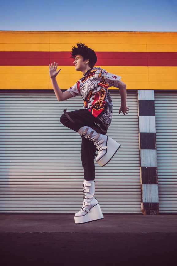 OCSA film TV senior jumps for the stars in this urban Costa Mesa alleyway that matches their outfit and vibe perfectly. by chele jones, oc senior portrait artist. Britt Kiley