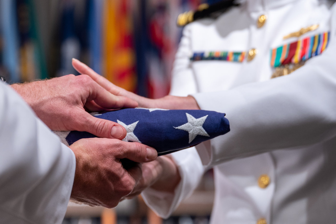 Naval officers passing an American Flag