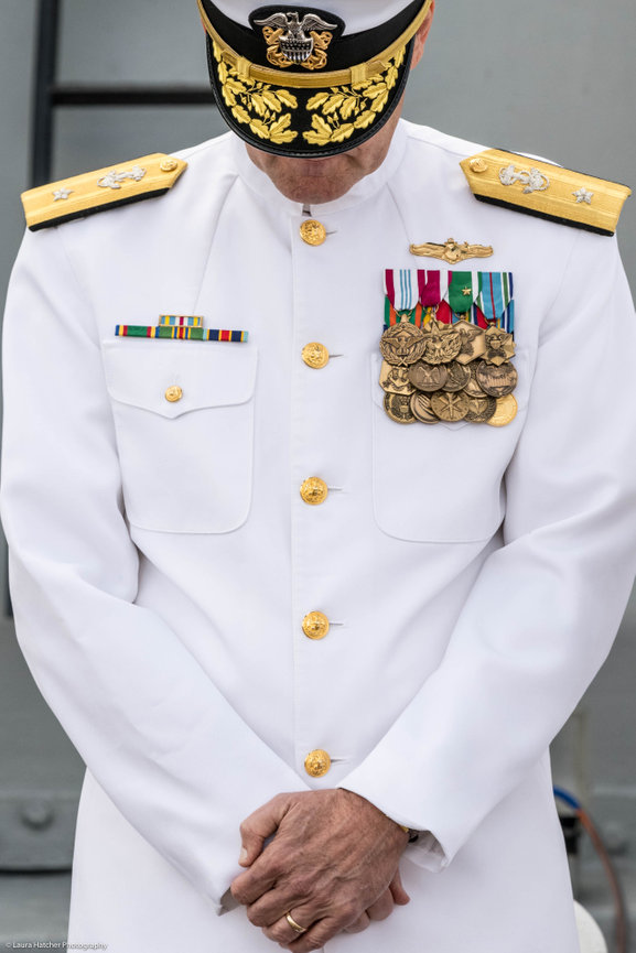 Navy Admiral bowing his head in prayer during a ceremony