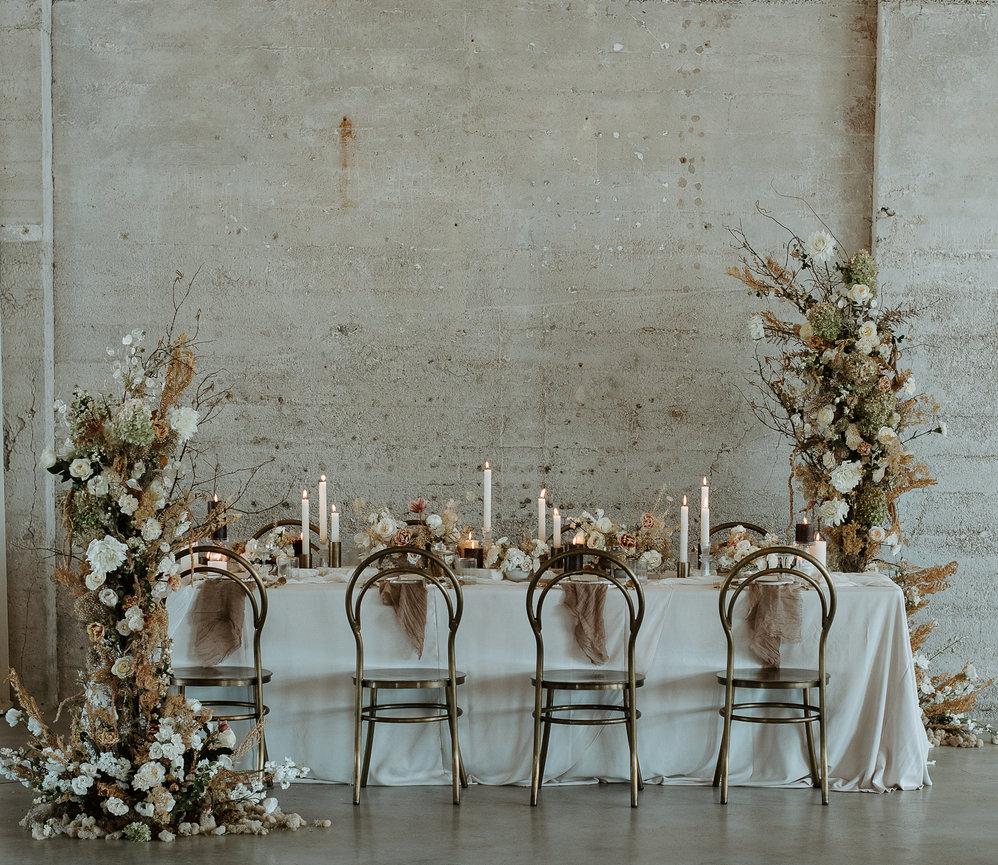 Luxurious winter Wedding setup , head table displaying the tablescape as well as the floral installation on the side of the table