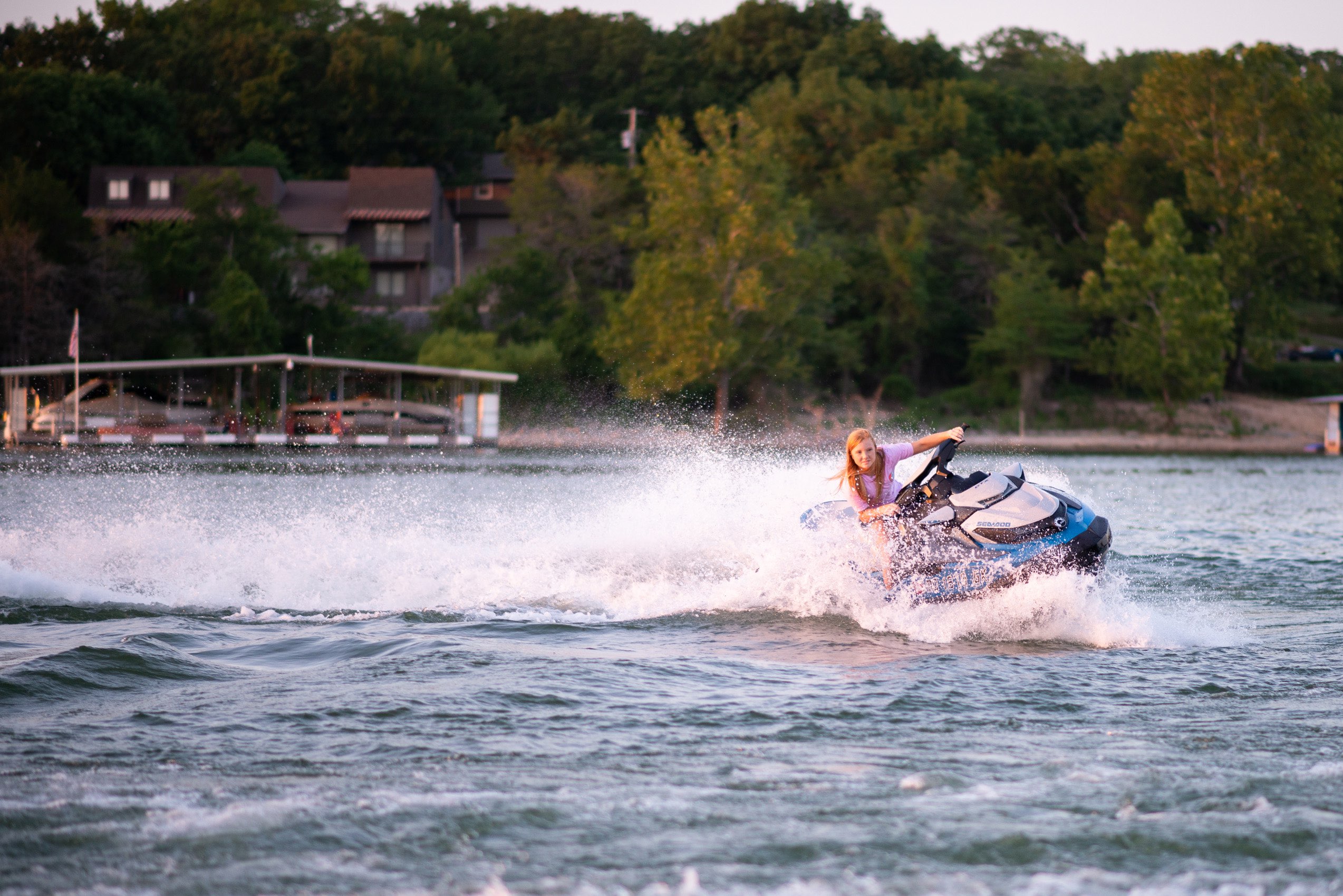 Senior girl in pink tshirt riding a jet ski at Tablerock Lake.