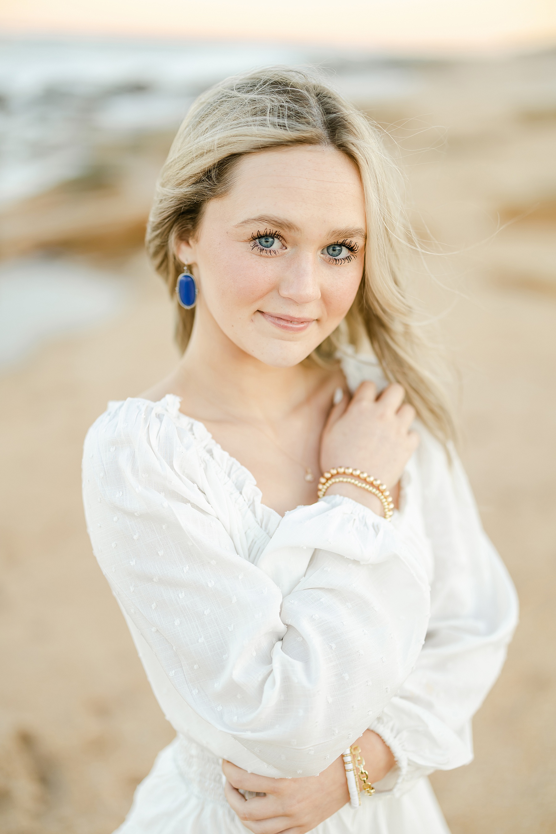 young blonde woman wearing white romper at the beach at sunset in saint augustine florida