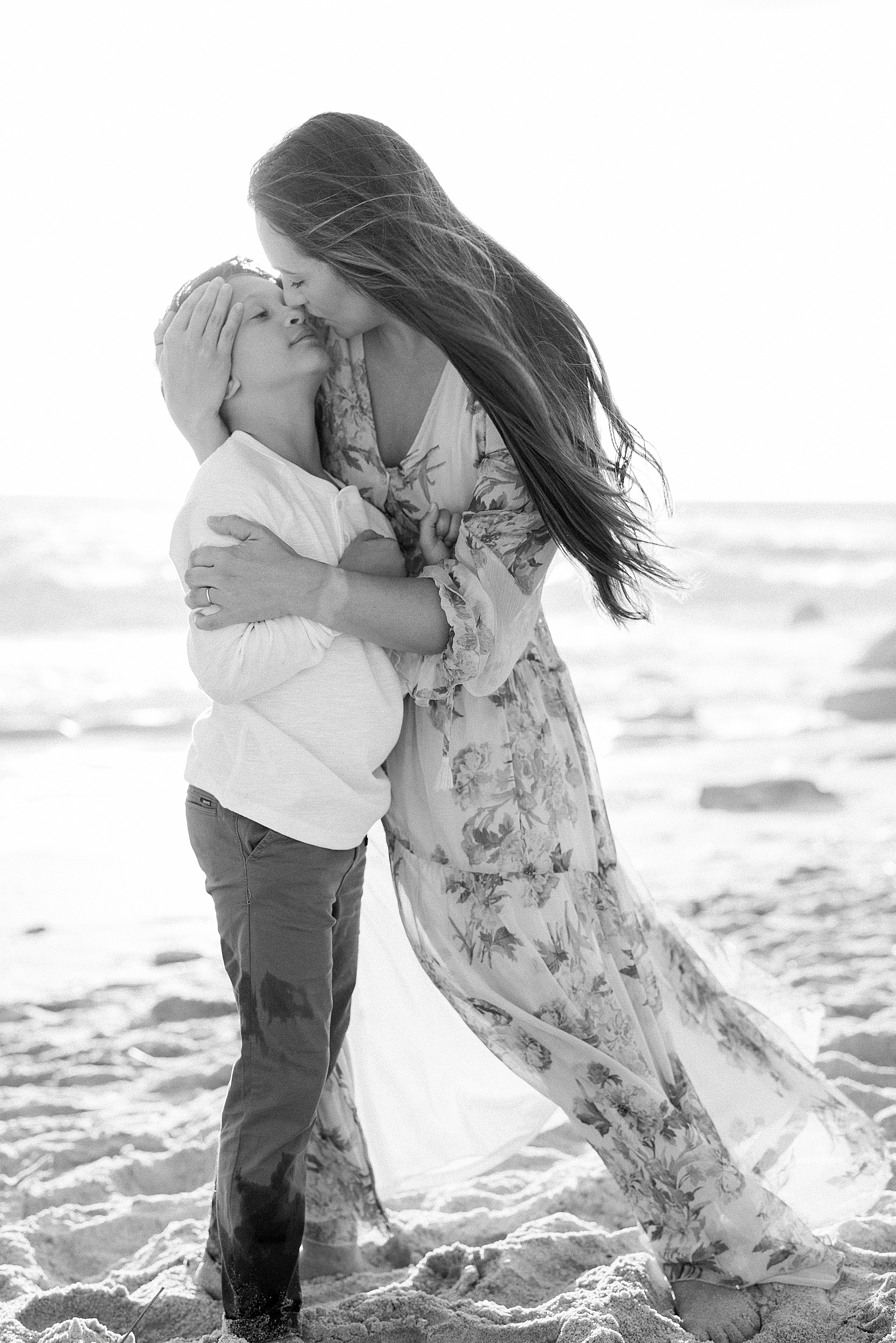 woman in sheer long floral dress holding boy on the beach in St. Augustine Florida