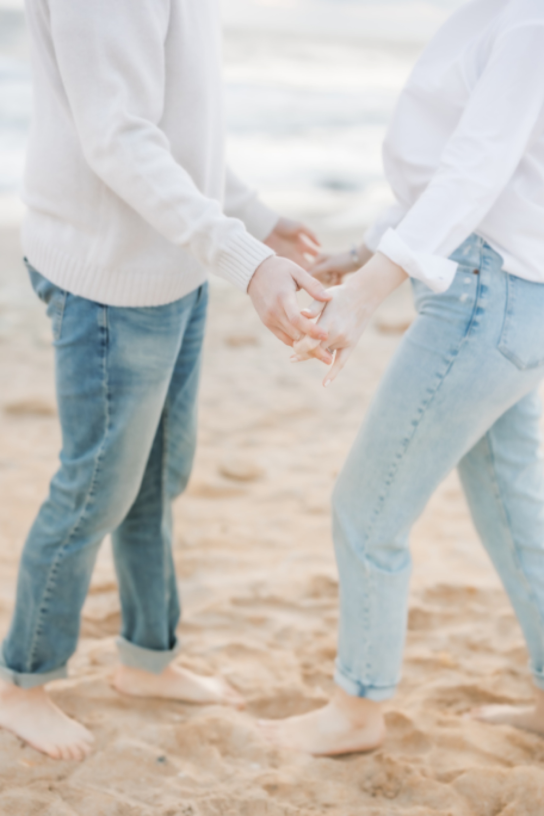 couple holding hands in jeans and white shirts