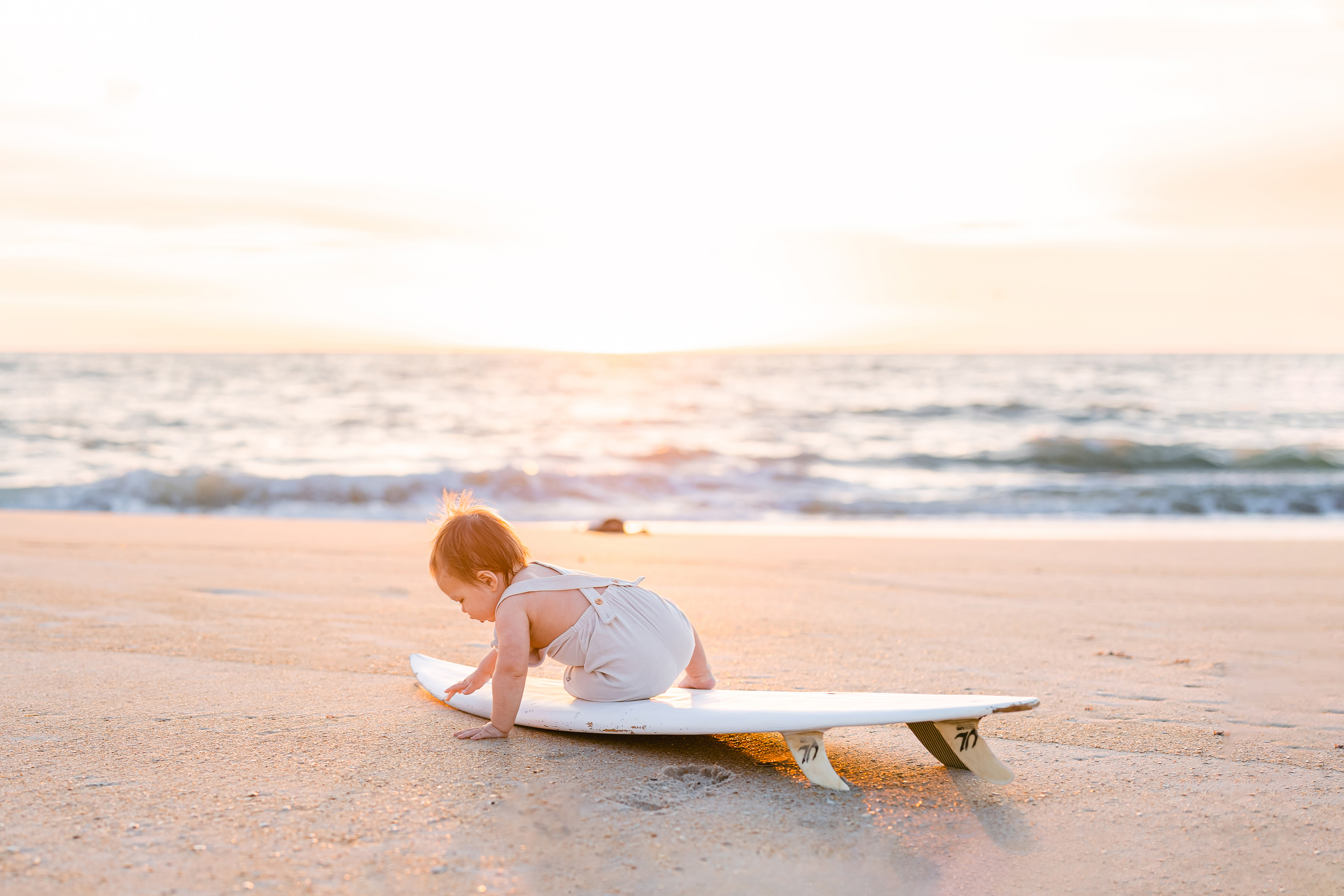 baby boy on surfboard at sunrise in Saint Augustine Beach Florida