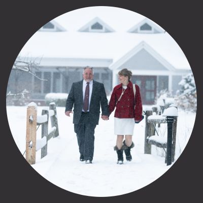 Older couple walking in snow in front of church