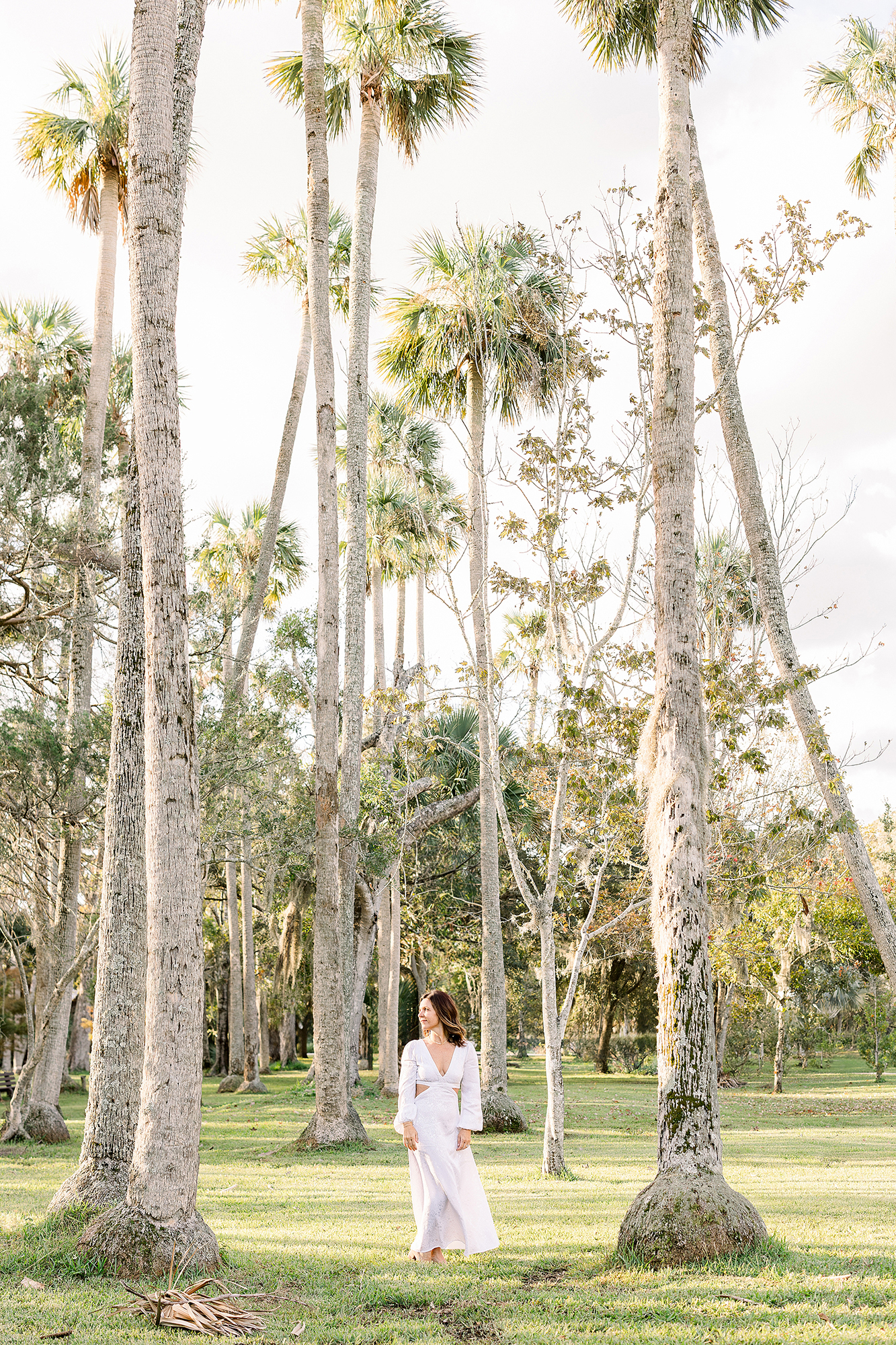 An airy portrait of a woman in a white dress standing amongst the trees at Johansen Park in Atlantic Beach, FL.