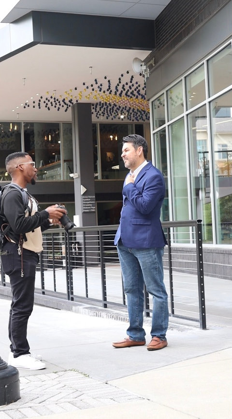 Two men conversing outside a building