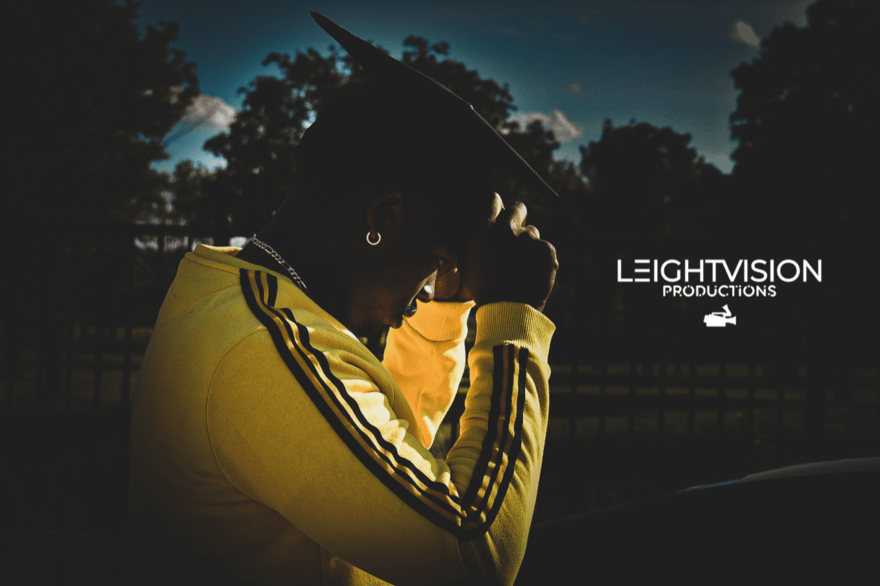 A man wearing a yellow jacket featuring the words Light Vision standing confidently against a neutral background.