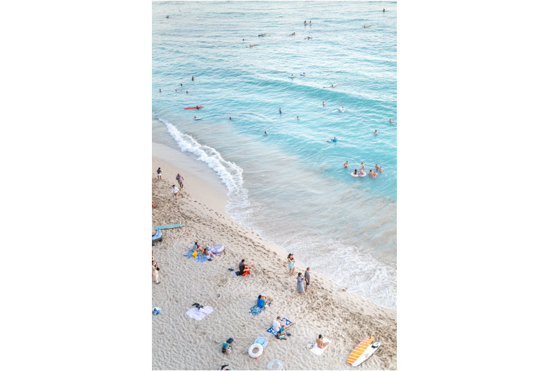 Beach Bliss by Andrea Bruns, an aerial view of swimmers, sunbathers, and gentle waves along Waikiki’s turquoise shoreline.