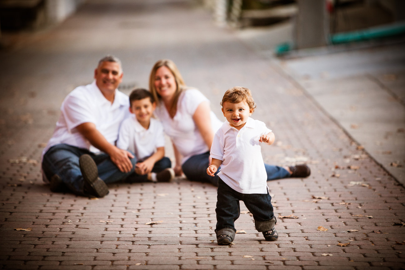 Family with young child sitting on a pathway