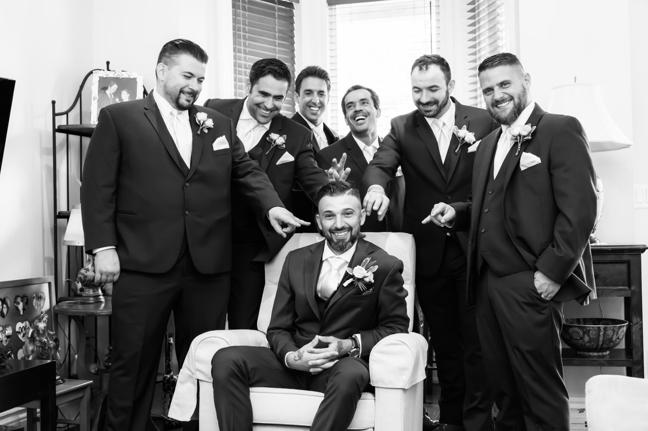 Groomsmen celebrating with the groom indoors