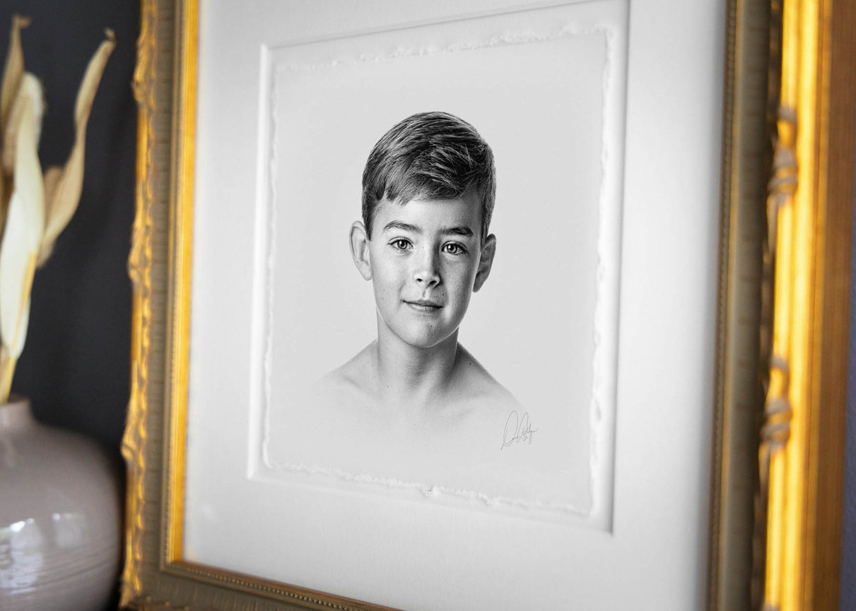 Charcoal headshot of a little boy in formal wear, captured in a timeless fine art style.