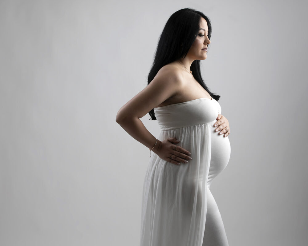 Pregnant woman with child standing in a garden