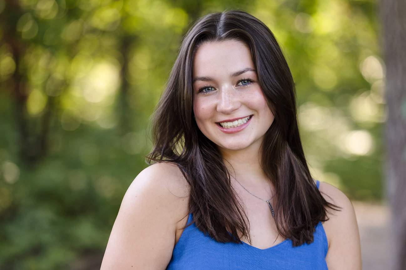 A high school senior girl with pretty blue eyes, smiling.
