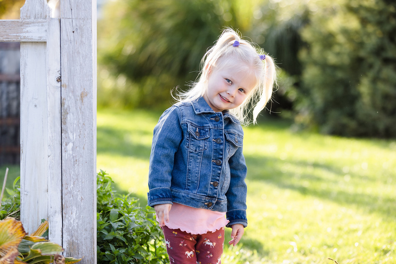 Blond-headed toddler, smiling at the camera for her picture. Taken on a farm in Caledonia, Michigan.