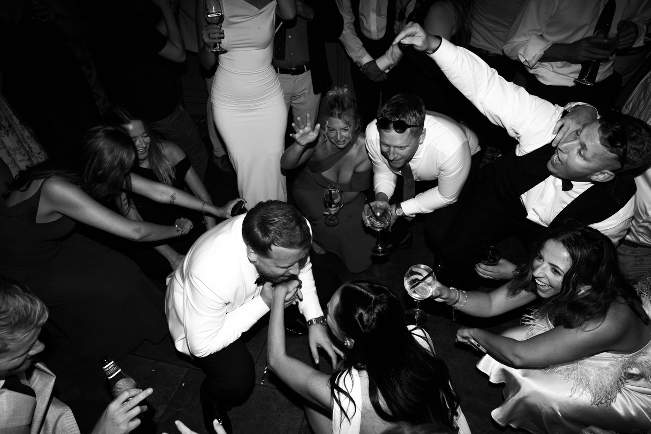 Candid black and white dance floor flash photography of a black tie couple at The Terrace, Warrington, capturing the raw energy of an editorial wedding party.