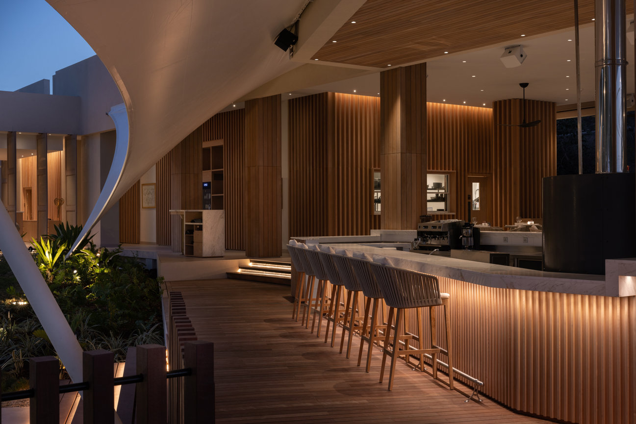 The Bar at Silversands Beach House designed with lots of wood throughout the interior covered with beautifully designed tents in the evening atmosphere.
