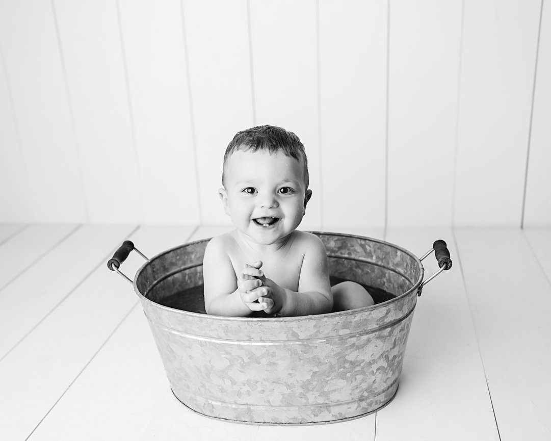 Black and white photo of baby in bathtub after cake smash photoshoot in Red Bank, NJ