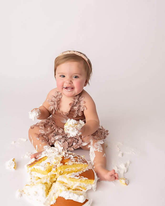 Candid moment of baby giggling with cake-covered hands
