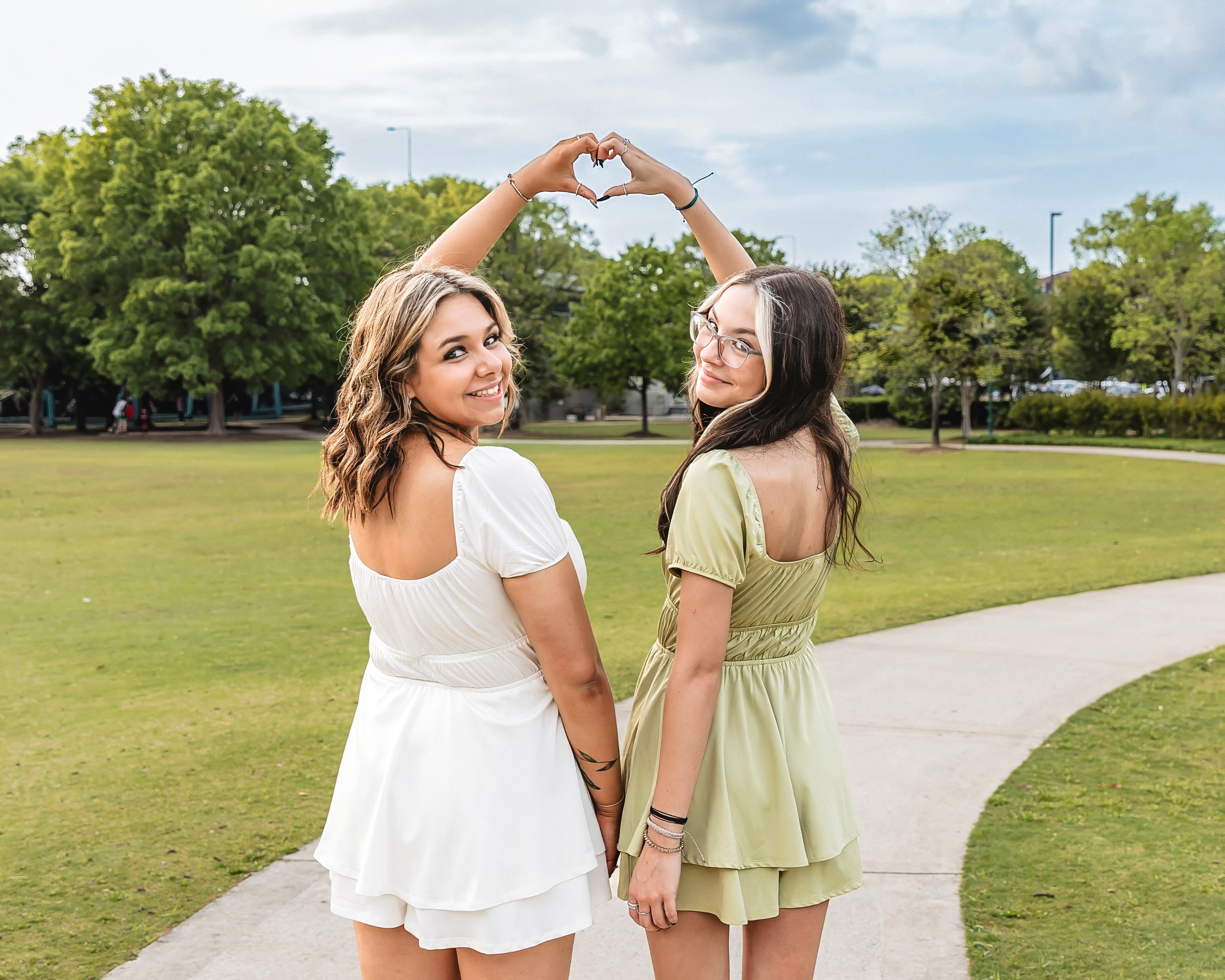 Best friends senior photoshoot making a heart shape with hands.