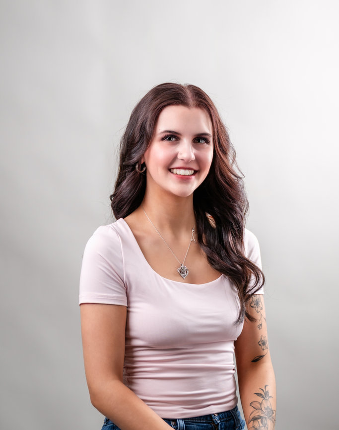 woman in pink shirt looking at the camera smiling
