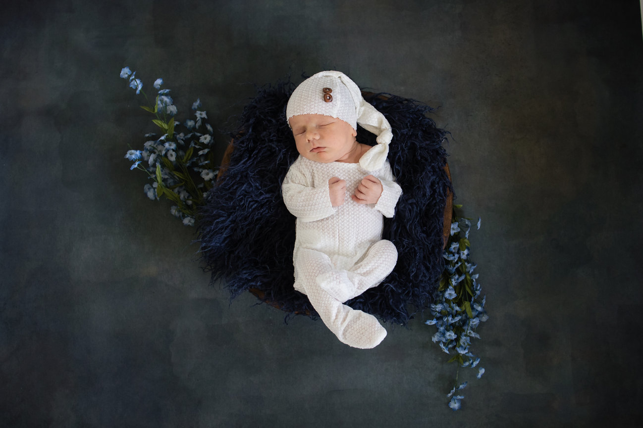 Newborn boy in bowl with blue flowers