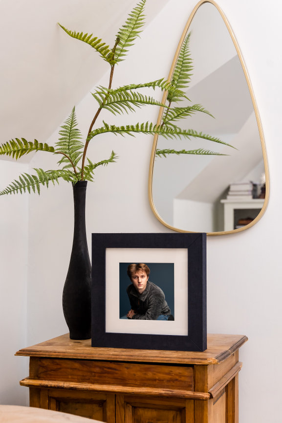 Fine art portrait in elegant frame displayed on wooden table, offered as IPS wall art by Fort Worth photographer Braly Studios.