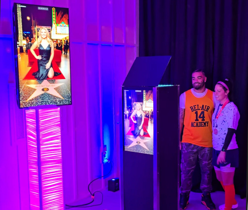 AI photo booth paired with a vertical LED light column and large slideshow display at an event.
