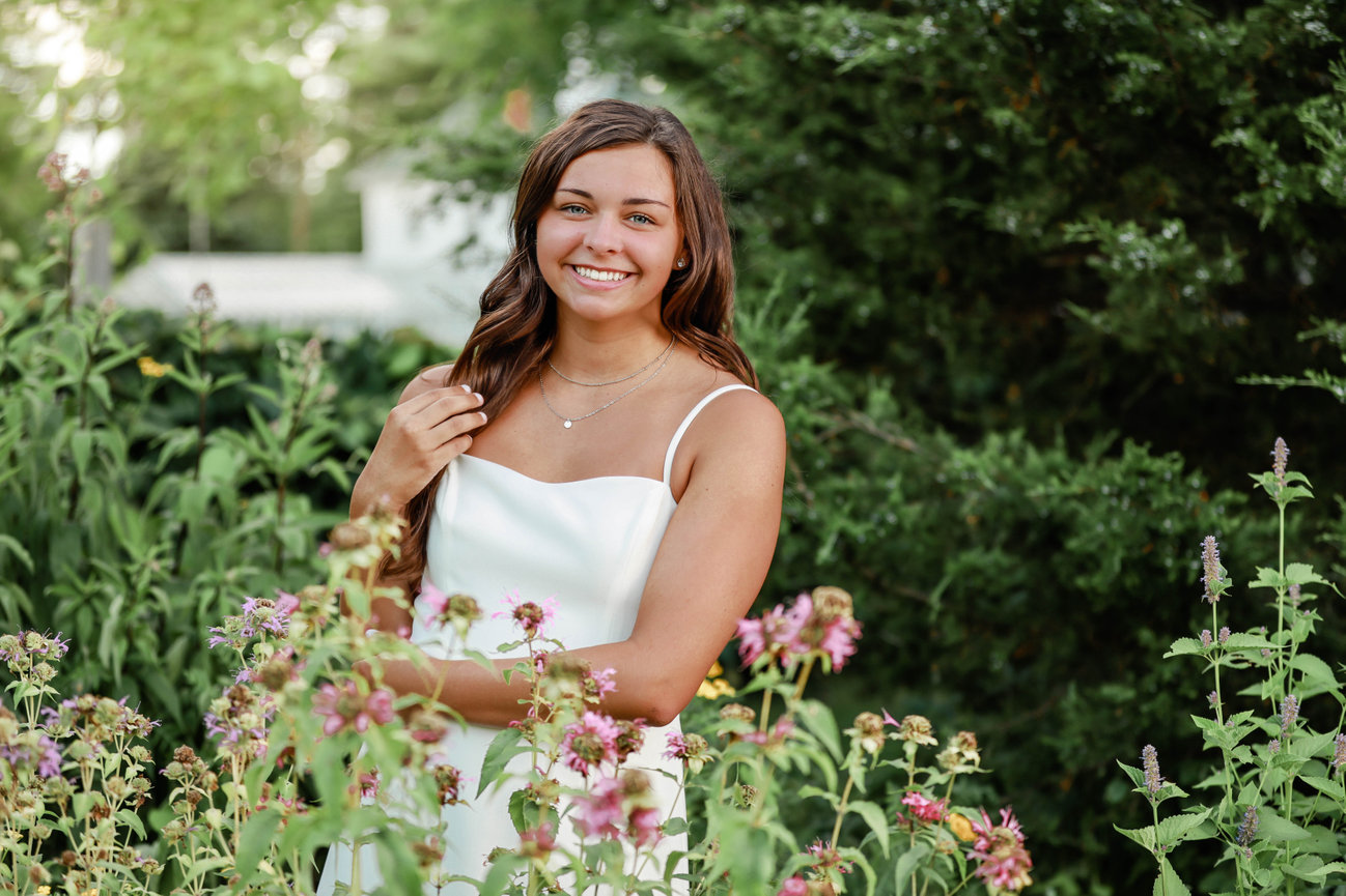 Teen girl smiling in formal dress outdoors in flowers in Farmington