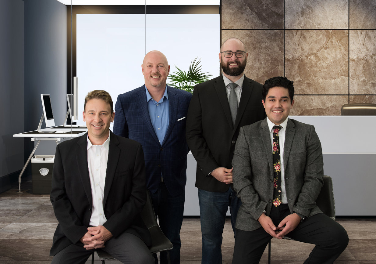 A team of 4 salesmen posing for a photograph in a Sandy, Utah office lobby.