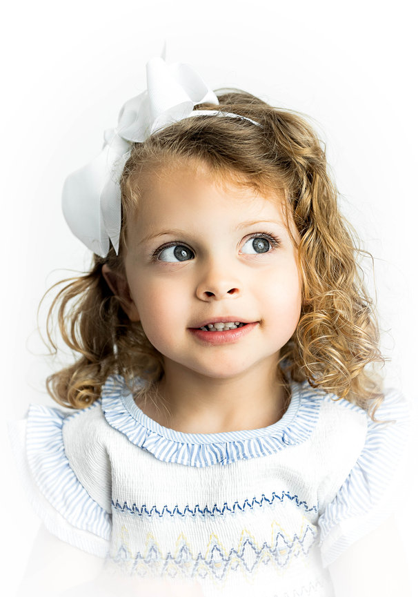 Soft vignetted portrait of toddler in heirloom wardrobe