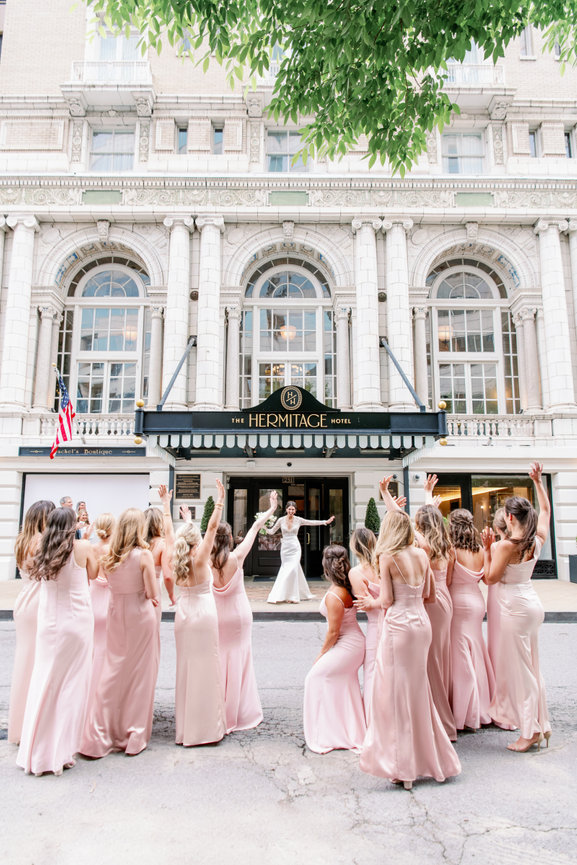 Bride exiting The Hermitage Hotel in Nashville and her bridesmaids seeing her for the first time. Bridesmaids reveal. Nashville wedding photography by Heather Durham.