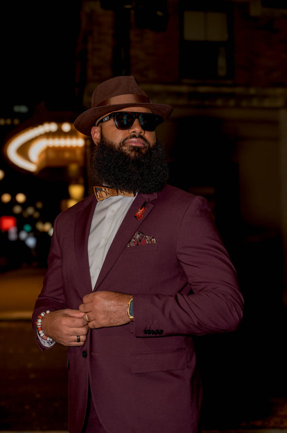 Man in maroon suit and hat with sunglasses on city street at night captured in the style of Jo Hayes Images Charlotte Event Photography Discovery Place Uptown