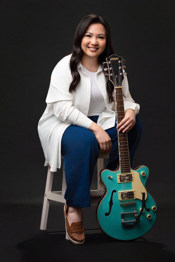 Relaxed portrait of a woman with her guitar