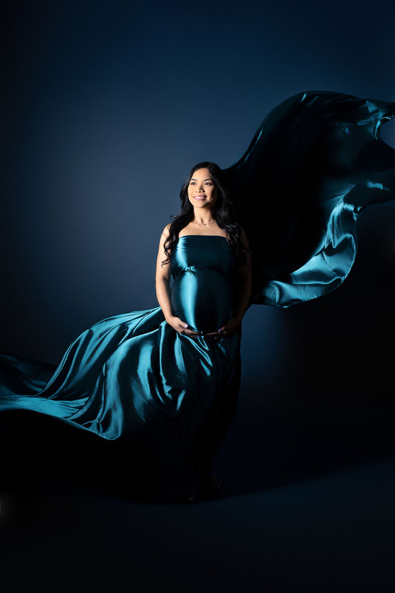 mother on a black background draped in teal fabric