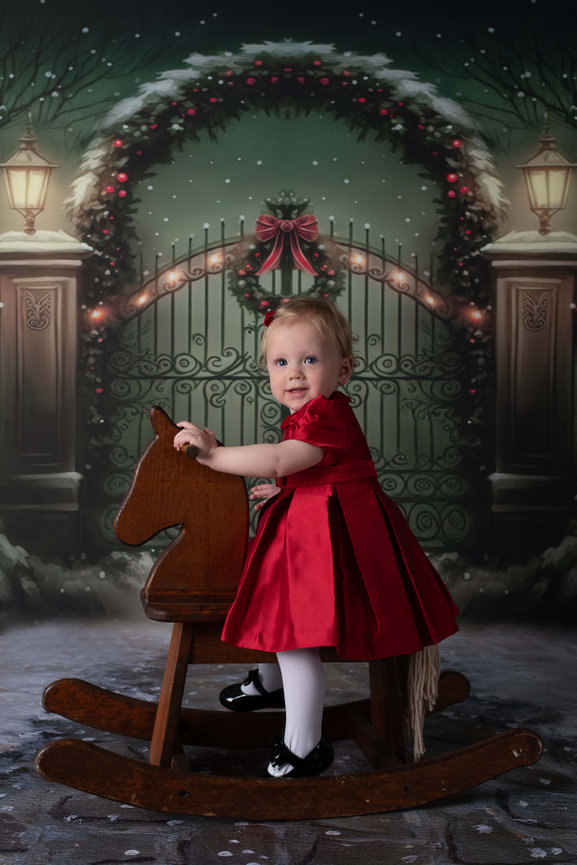 A little girl in her Christmas dress riding a rocking horse